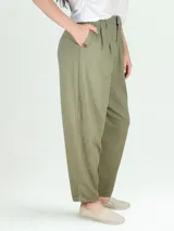 Pantalón de lino color verde oliva, de corte holgado, con pinzas en la cintura y bolsillos laterales.