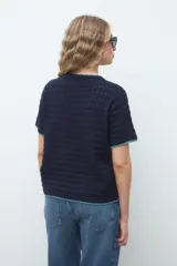 Remera de punto azul marino con mangas cortas, cuello redondo y detalles de terminación en hilo verde menta.