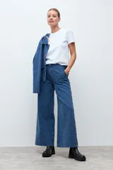 Pantalón de jean de corte recto y tiro alto, confeccionado en denim azul con una textura sutil de pequeños puntos en relieve.