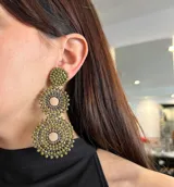 Aros colgantes con forma de tres círculos concéntricos tramados con cristales color verde oliva y detalles en plateado.