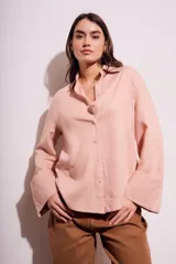 Camisa color salmón de corte oversize, confeccionada en lino y viscosa, con cuello clásico, cierre frontal con botones y mangas largas con puños anchos.