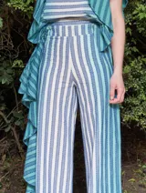 Pantalón de lino y algodón a rayas verticales en tonos celeste y blanco, con corte palazzo y volados en el lateral.