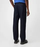 Pantalón de jean azul marino con corte recto y estilo semi sastrero, confeccionado en denim crudo de algodón, con pinzas frontales y trabillas para cinturón.
