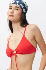 Top de bikini blanco con escote halter, abertura circular en el centro y lazos ajustables.