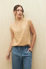 Top sin mangas confeccionado en mezcla de lino y viscosa, de silueta recta y caída relajada. Presenta hombros levemente marcados, cuello redondo y detalle de botones forrados en la espalda.