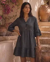 Vestido corto verde militar de lino, con cuello mao, escote en V con botones, mangas tres cuartos acampanadas con volados y falda con volado en el ruedo.