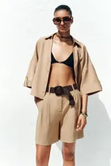 Bermuda de tiro alto color azul marino, con pinzas delanteras, bolsillos laterales y cinturón trenzado color marrón.