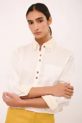 Camisa blanca de lino con cuello clásico y puños con detalle de crochet.