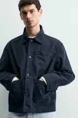 Sobrecamisa de corte relajado confeccionada en tejido de algodón con estructura canvas y efecto lavado. Presenta cuello solapa, cierre frontal con botones, mangas largas con puños abotonados y tres bolsillos frontales de plastrón.