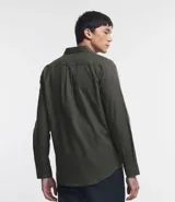 Camisa de manga larga confeccionada en tricolina de algodón, con cuello inglés, cierre frontal de botones y puños abotonados. Diseño liso y versátil.