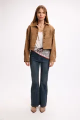 Chaqueta de efecto gamuza en color marrón, con diseño de flecos en la parte frontal y trasera, cuello clásico y cierre frontal con botones metálicos a presión.