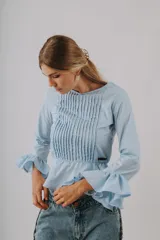 Camisa de manga larga color negro con detalles de alforzas en el pecho, corte peplum y puños acampanados con volados.