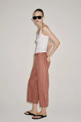 Jeans Zara Woman Collection de tiro alto y corte tapered, con diseño de rayas verticales a contraste en color marrón y beige. Presenta cinco bolsillos, trabillas para cinto y cierre frontal con cremallera y botón.