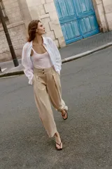 Pantalón de tiro bajo con pinzas delanteras, bolsillos frontales y bolsillos de plastrón con solapa en la parte trasera. Presenta una pernera ancha y bajo con botones a presión para ajuste.