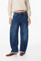 Jean de corte wide leg y tiro medio, confeccionado en denim azul con lavado localizado. Presenta diseño de cinco bolsillos, cierre frontal con botón y ruedo con dobladillo.