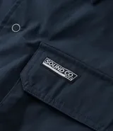 Camisa de manga corta Ripping, confeccionada en tricolina de algodón. Presenta un corte boxy relajado, cuello inglés, cierre frontal con botones y dos bolsillos cargo en el pecho con etiqueta bordada.