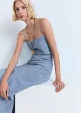 Vestido midi de corte recto con diseño estilo vaquero, confeccionado en una mezcla de algodón y lino. Presenta un escote cuadrado, tirantes finos ajustables y un detalle drapeado en uno de los laterales de la cintura. Cuenta con cierre de cremallera lateral.