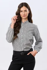 Camisa de algodón celeste con estampado floral pequeño, cuello mao, mangas largas con puños fruncidos y cierre frontal de botones.