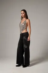 Top halter plateado de malla metálica con escote buche y tirantes de cadena fina.