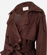 Trench coat de gamuza sintética color marrón chocolate, con cuello solapa, cierre frontal cruzado con botones y cinturón ajustable en la cintura. Presenta mangas largas con reguladores en los puños y diseño de corte largo.
