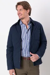 Campera azul marino capitoneada con cuello de pana, cierre frontal con botones a presión, bolsillos laterales y un bolsillo plaque en el pecho.