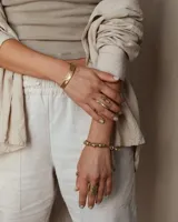 Pulsera tipo esclava abierta con diseño rústico y acabado irregular, fabricada en bronce y alpaca.