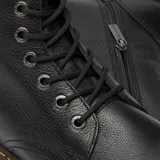 Botas de caña media Dr. Martens modelo Jadon III, confeccionadas en cuero Pisa negro con acabado texturizado. Presentan cierre de cordones con 8 ojales metálicos, suela de plataforma Quad con costuras amarillas en la vira y presilla trasera característica de la marca.