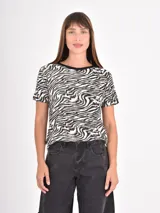 Remera de manga corta con cuello redondo, confeccionada con un estampado animal print de leopardo en tonos negros y beige.