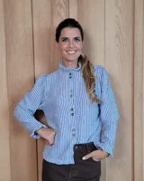 Camisa de manga larga con estampado de rayas verticales en tonos crudo y beige. Presenta cuello alto con volados, cierre frontal con botones dobles y puños con volados.