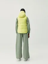 Chaleco acolchado reversible con capucha, cierre frontal de cremallera y bolsillos laterales. Diseño cortavientos y funcional con relleno vegano.