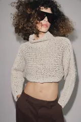 Jersey corto de punto con diseño de cinta entrelazada, cuello subido y manga larga.