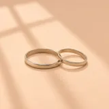 Par de alianzas de plata con diseño clásico de cinta lisa.