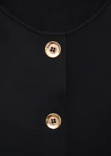 Chaleco de punto fino color negro, con cuello redondo, diseño recto sin mangas y cierre frontal de botones dorados.