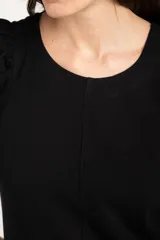 Remera de algodón negro con mangas cortas abullonadas, cuello redondo y costura central frontal.