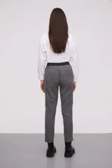 Pantalón gris a rayas verticales, de corte recto y tiro alto.