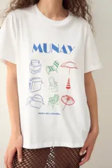 Remerón blanco oversize de algodón, con estampado frontal de estilo playero que incluye un cocodrilo, un paraguas de playa, una silla de playa y otros elementos.