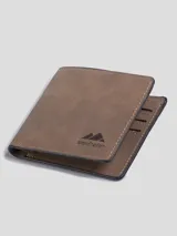 Billetera plegable de diseño clásico en color marrón con acabado tipo nobuk. Presenta costuras a la vista en los bordes y el logo de la marca grabado en la parte frontal. Cuenta con múltiples compartimentos internos para tarjetas, billetes y documentos.
