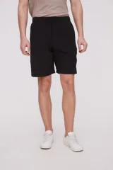 Bermuda de corte recto y diseño minimalista, confeccionada en tejido técnico de poliéster. Presenta cintura elástica con cierre de botón frontal, bolsillos laterales y un bolsillo pequeño adicional en el lateral izquierdo.