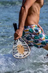 Short de baño con estampado tropical de hojas y elementos lineales sobre fondo blanco. Cuenta con cintura elástica, dos bolsillos laterales, un bolsillo trasero con etiqueta de la marca Von Braun y red interior.