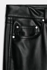 Pantalón de tiro medio confeccionado en tejido efecto piel, con diseño de cinco bolsillos y cierre frontal con cremallera y botón.