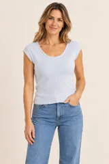 Remera celeste de tejido acanalado con mangas cortas y detalle de aplicación de perlas en el escote y en los bordes de las mangas.
