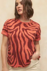 Remera de manga corta color naranja con estampado de cebra en color marrón.