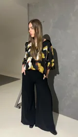 Blusa de manga larga acampanada con estampado abstracto en tonos negro, blanco, verde lima y caramelo, de corte holgado.