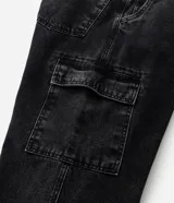Pantalón de jean negro, estilo baggy, con bolsillos cargo laterales y efecto lavado.