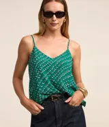 Blusa de crepe verde con estampado geométrico en blanco y negro, escote en V y tirantes finos.