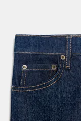 Jeans de mezclilla azul claro, tiro medio, corte recto y ligeramente acampanado en el bajo. Presenta cinco bolsillos y cierre frontal con cremallera y botón metálico.