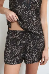 Conjunto de pijama de satén rojo, compuesto por un top de breteles finos con detalle de puntilla en el escote y un short con cintura elastizada y lazo ajustable.