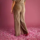 Pantalón de corte ancho y fluido, confeccionado en tela de terciopelo plisado color marrón topo. Presenta una cintura elástica cómoda y un diseño de pierna recta y holgada.