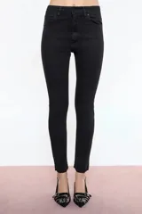 Jean negro de denim elastizado, de calce high skinny, tiro alto, avios marcarios negros y chapita Ginebra en el bolsillo trasero.