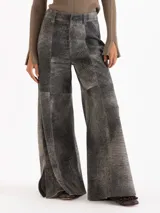 Pantalon de cuero ovino gris con diseño de pata ancha y recortes geométricos a la altura de las rodillas.